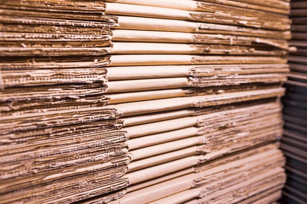 Stacks of folded corrugated board used to make shipping boxes